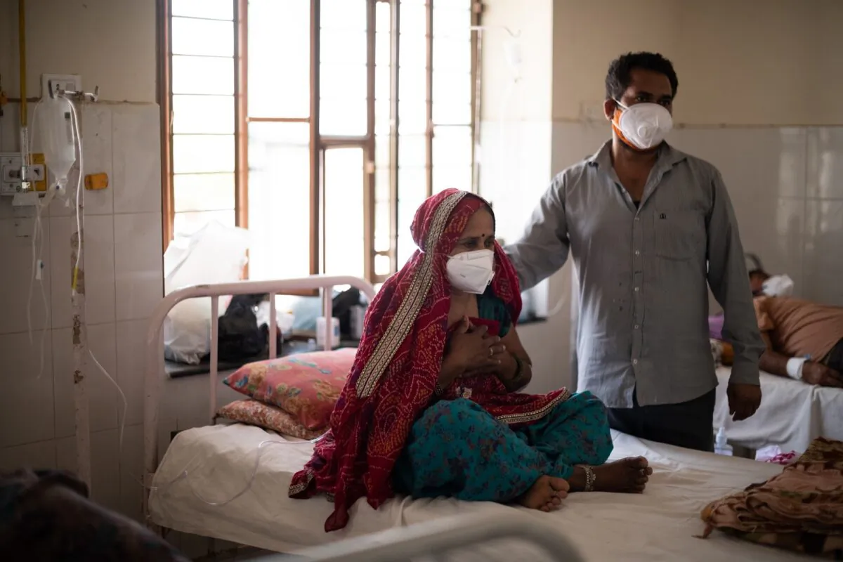 An Indian relative comforts a patient as she receives supplemental oxygen during treatment for the coronavirus at the Kapil Government Hospital, which became a coronavirus consultation and treatment facility serving villages in the Jaipur and Sikar districts, on May 15, 2021 in Neem Ka Thana, Sikar District, Rajasthan, India. (Rebecca Conway/Getty Images)