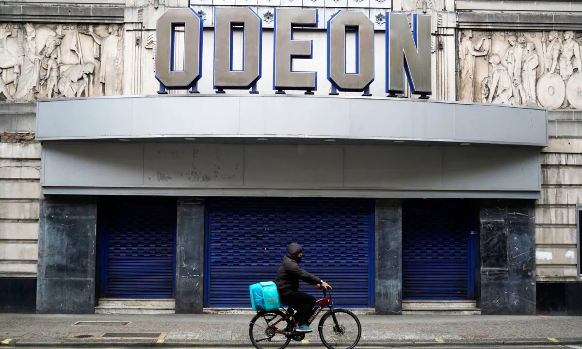A deliveroo rider passes the Odeon cinema in Leicester Square in central London on May 16, 2021. (Niklas Halle'n/AFP via Getty Images)