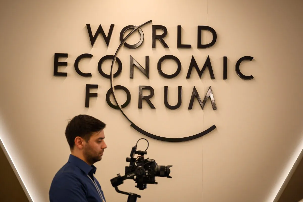A cameraman works in front of a logo of the World Economic Forum in Davos, eastern Switzerland, on Jan. 20, 2019. (Fabrice Coffrini/AFP via Getty Images)