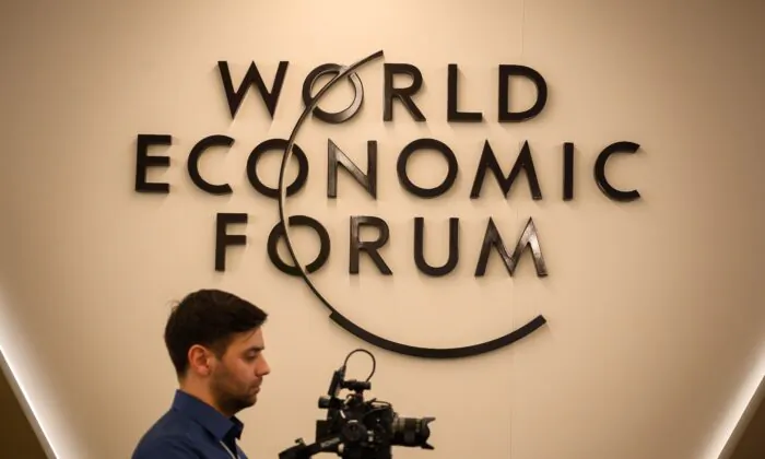 A cameraman works in front of a logo of the World Economic Forum in Davos, eastern Switzerland, on Jan. 20, 2019. (Fabrice Coffrini/AFP via Getty Images)