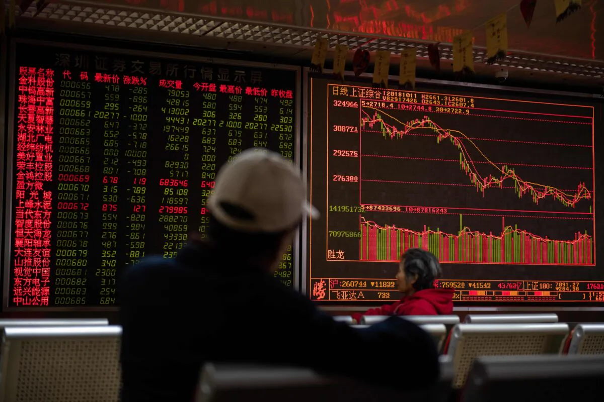 Investors look at stock price movements on a screen showing stock prices at a securities company in Beijing on Oct. 11, 2018. (Nicolas Asfouri/AFP via Getty Images)