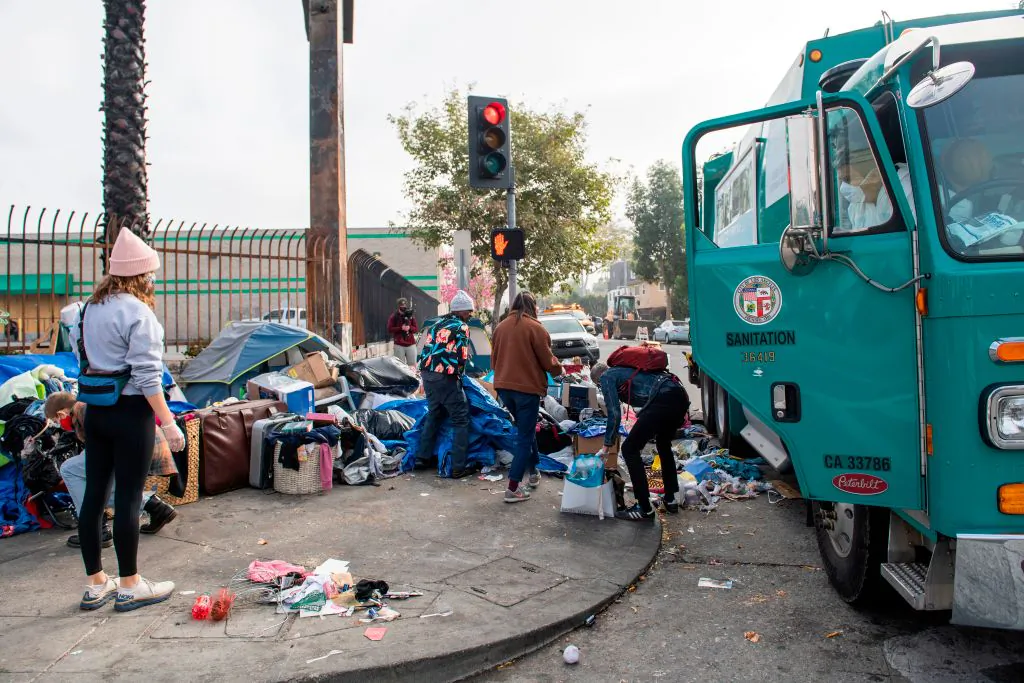 Activists help protect homeless people from being displaced by street cleaning and power washing from the Los Angeles Sanitation service in Hollywood, Calif., on Feb. 8, 2021. (Valerie Macon/AFP via Getty Images)