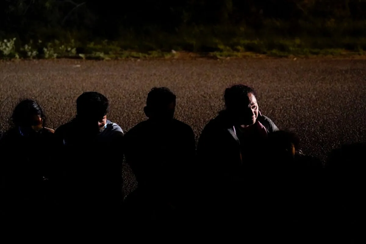 A group of migrants, mainly from Honduras and Nicaragua, wait along a road after turning themselves in upon crossing the U.S.-Mexico border in La Joya, Texas on Monday, May 17, 2021. (Gregory Bull/AP Photo File)
