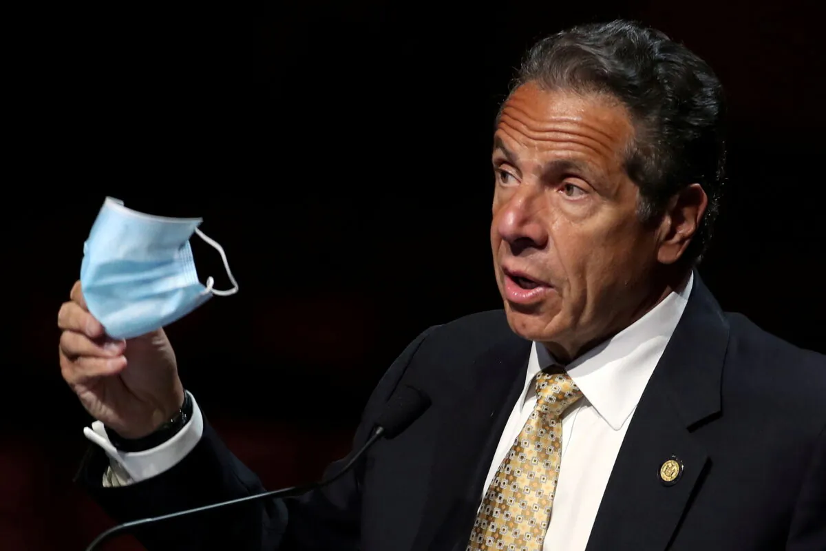 New York Governor Andrew Cuomo holds a protective mask as he speaks while making an announcement at a news conference from the stage at Radio City Music Hall in Manhattan in New York City, New York, on May 17, 2021. (Mike Segar/File Photo/Reuters)