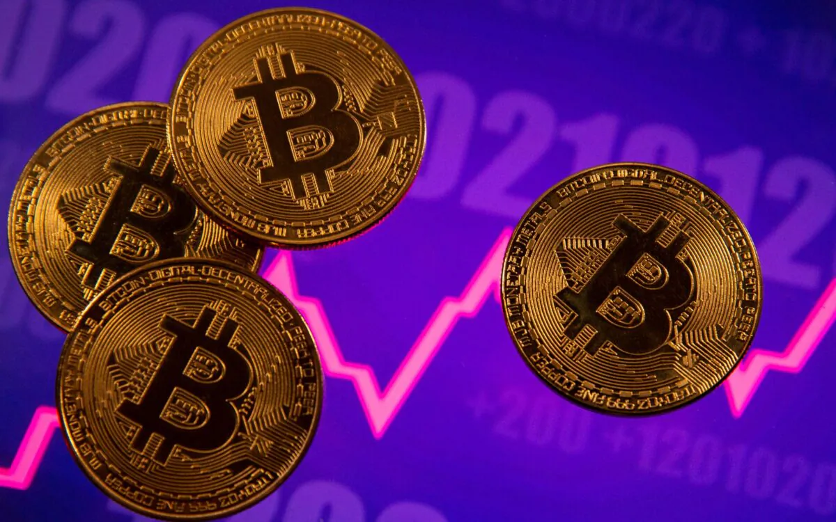 A representation of virtual currency Bitcoin is seen in front of a stock graph in this illustration on March 15, 2021. (Dado Ruvic/Reuters)
