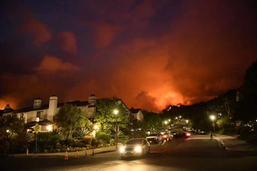 Flames from the Palisades fire glow in the distance in Topanga, northwest of Los Angeles, on May 15, 2021.   Patrick T. Fallon/AFP via Getty Images)