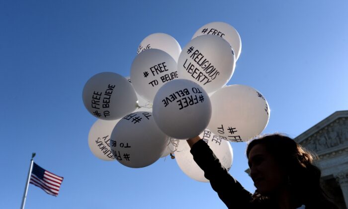 A protester holds balloons calling for religious freedom outside the U.S. Supreme Court in Washington on April 28, 2015. (Olivier Douliery/Getty Images)