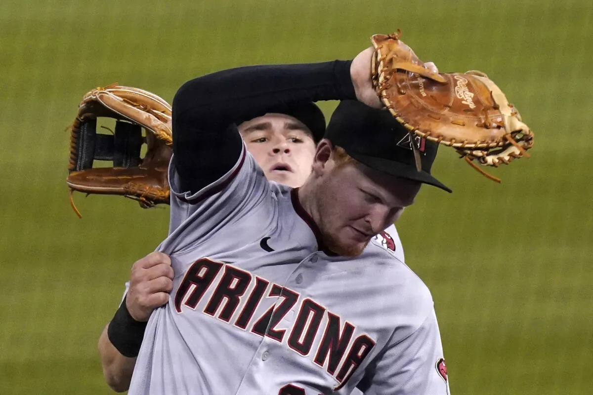 Arizona Diamondbacks first baseman Pavin Smith (R) makes a catch on a ball hit by Los Angeles Dodgers' Will Smith as second baseman Andrew Young collides with him during the fifth inning of a baseball game, in Los Angeles, Calif., on May 18, 2021. (Mark J. Terrill/AP Photo)