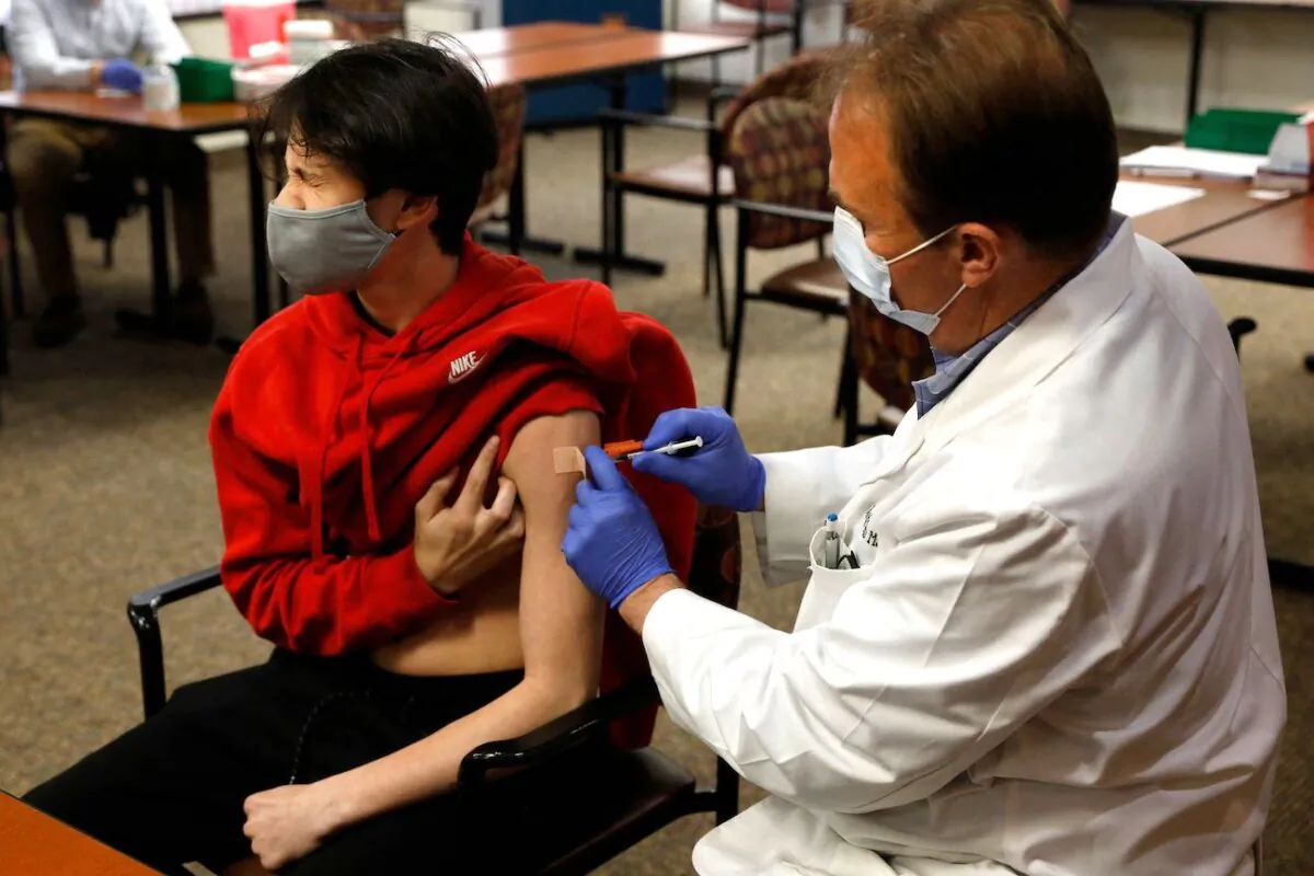 A 15-year-old receives the Pfizer-BioNTech vaccine against the CCP virus in Bloomfield Hills, Michigan, on May 13, 2021. (Jeff Kowalsky/AFP via Getty Images)