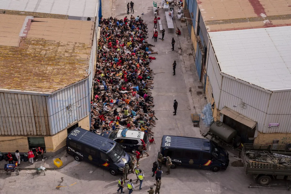 Unaccompanied minors who crossed into Spain are gathered outside a warehouse used as temporary shelter as they wait to be tested for COVID-19 at the Spanish enclave of Ceuta, near the border of Morocco and Spain, on May 19, 2021. (Bernat Armangue/AP Photo)