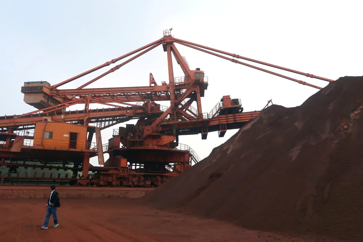 A man walks by an iron ore blending site at Dalian Port, Liaoning province, China Sept. 21, 2018. (Muyu Xu/Reuters)