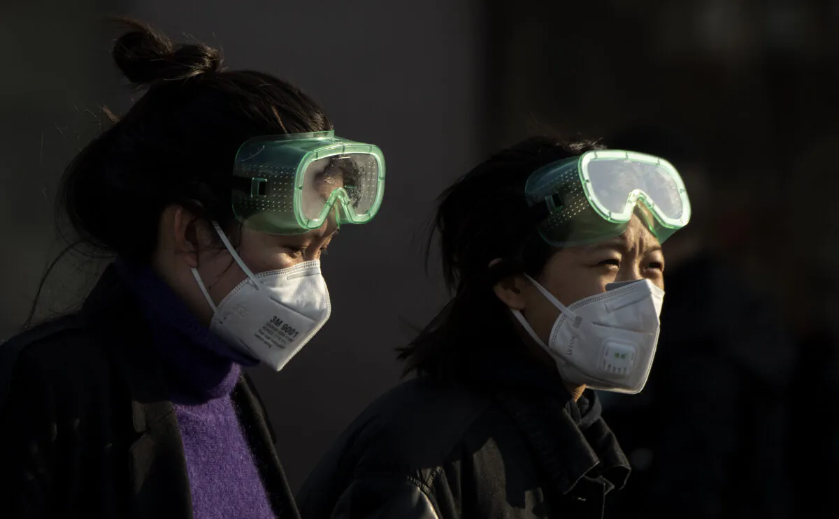 Travelers wearing masks arrive from various provinces at the Beijing Railway Station on Feb. 3, 2020. (Noel Celis/AFP via Getty Images)