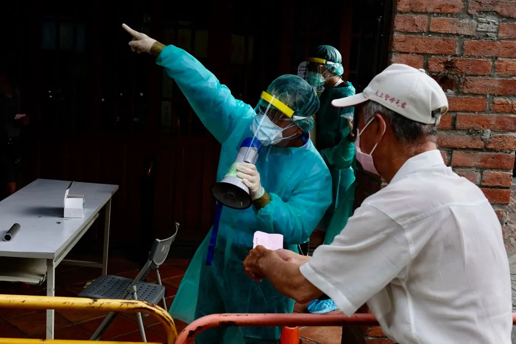 A local resident listens to medical staff before queuing up for the COVID-19 virus testing at the Wanhua District in Taipei, Taiwan, on May 19, 2021. (SAM YEH/AFP via Getty Images)