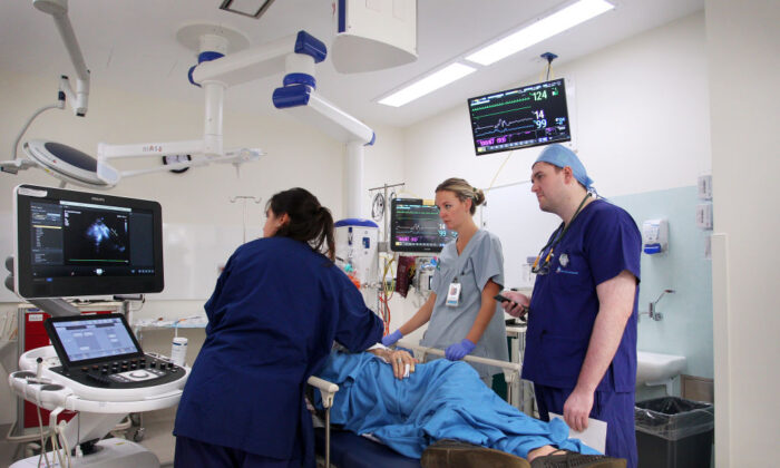 Emergency medical staff and Callum Cherrett Cardiology AT (C) treat a patient with suspected heart issues in the Emergency Department of St Vincent's Hospital in Sydney, Australia, on June 04, 2020. (Lisa Maree Williams/Getty Images)