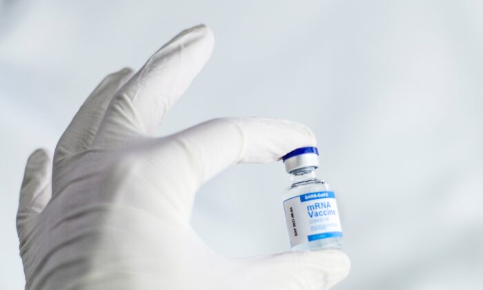 A hand holding an mRNA vaccine vial. (Spencer Davis/Unsplash)
