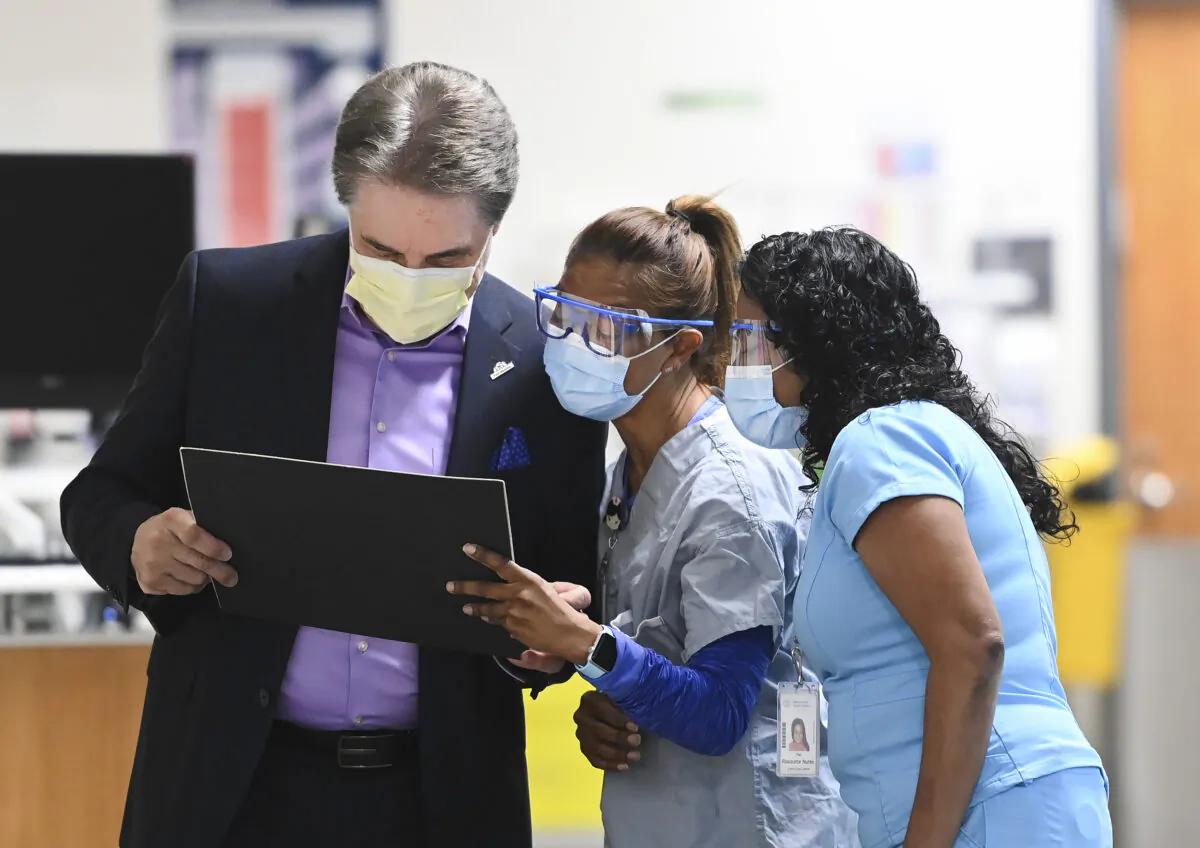 Nurses look at information with a doctor at the Peel Memorial Centre for Integrated Health and Wellness, within the William Osler Health System, during the COVID-19 pandemic in Brampton, Ont., on March 26, 2021. (The Canadian Press/Nathan Denette)