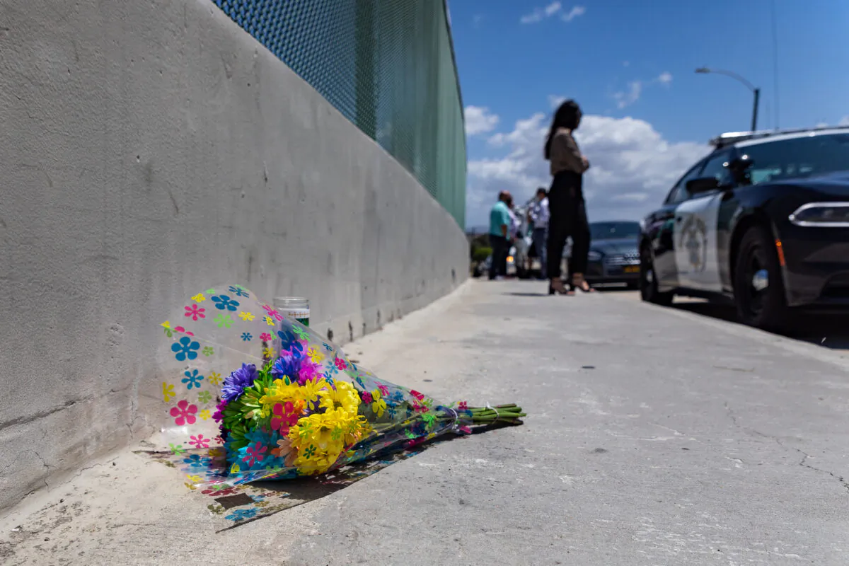 Officers, civilians, and media stand on an overpass next to an area on the 55 Freeway where a shooting believe to have been prompted by road rage killed a six-year-old boy May 21, 2021 in Orange, Calif. (John Fredricks/The Epoch Times)