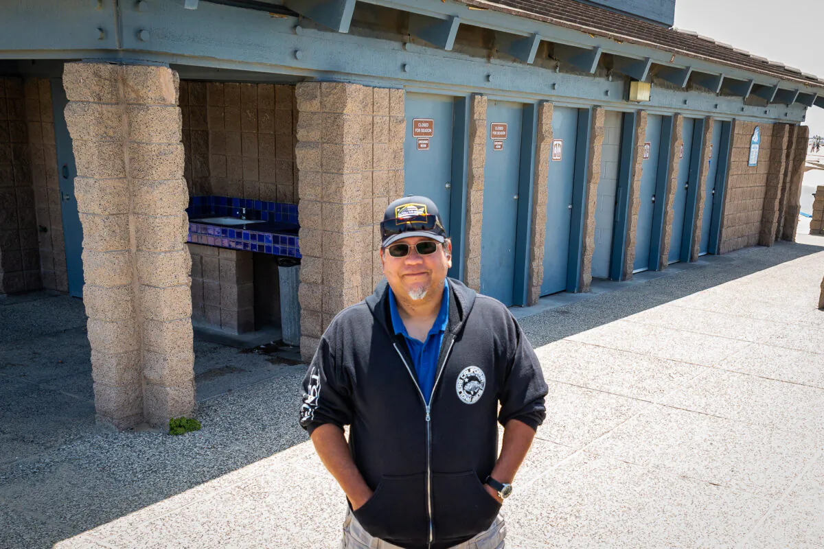 Rolando Galvan stands near the public restrooms by lifeguard tower 13 in Huntington Beach, Calif., on May 20, 2021. (John Fredricks/The Epoch Times)