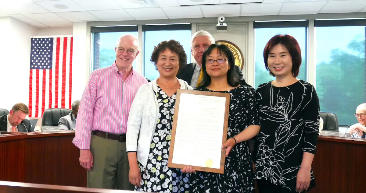 Robert F. Babyok, Jr. (C), chairman of Louisa County board of supervisors, and local resident hold the resolution condemning forced organ harvesting in China, in Louisa County, Va., on May. 17, 2021. (Sherry Dong/The Epoch Times)
