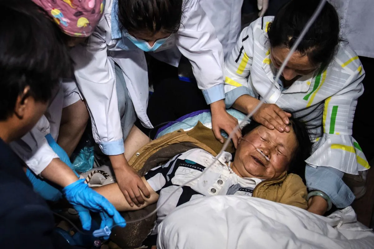 Medical workers treat a woman after an strong earthquake in Yangbi Yi Autonomous County in southwestern China's Yunnan Province on May 22, 2021.(Hu Chao/Xinhua via AP)