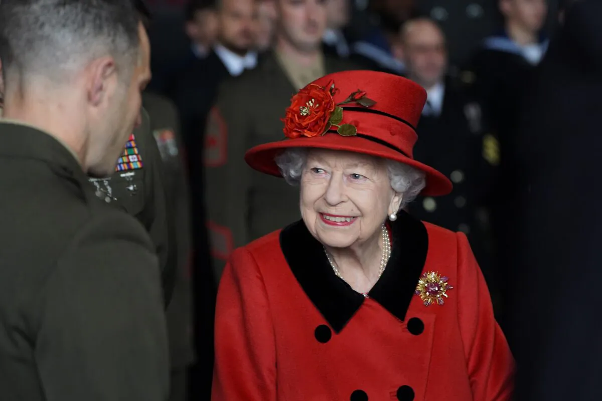 Queen Elizabeth II talks to military personnel during a visit to HMS Queen Elizabeth at HM Naval Base ahead of the ship's maiden deployment, in Portsmouth, England, on May 22, 2021. (Steve Parsons - WPA Pool / Getty Images)