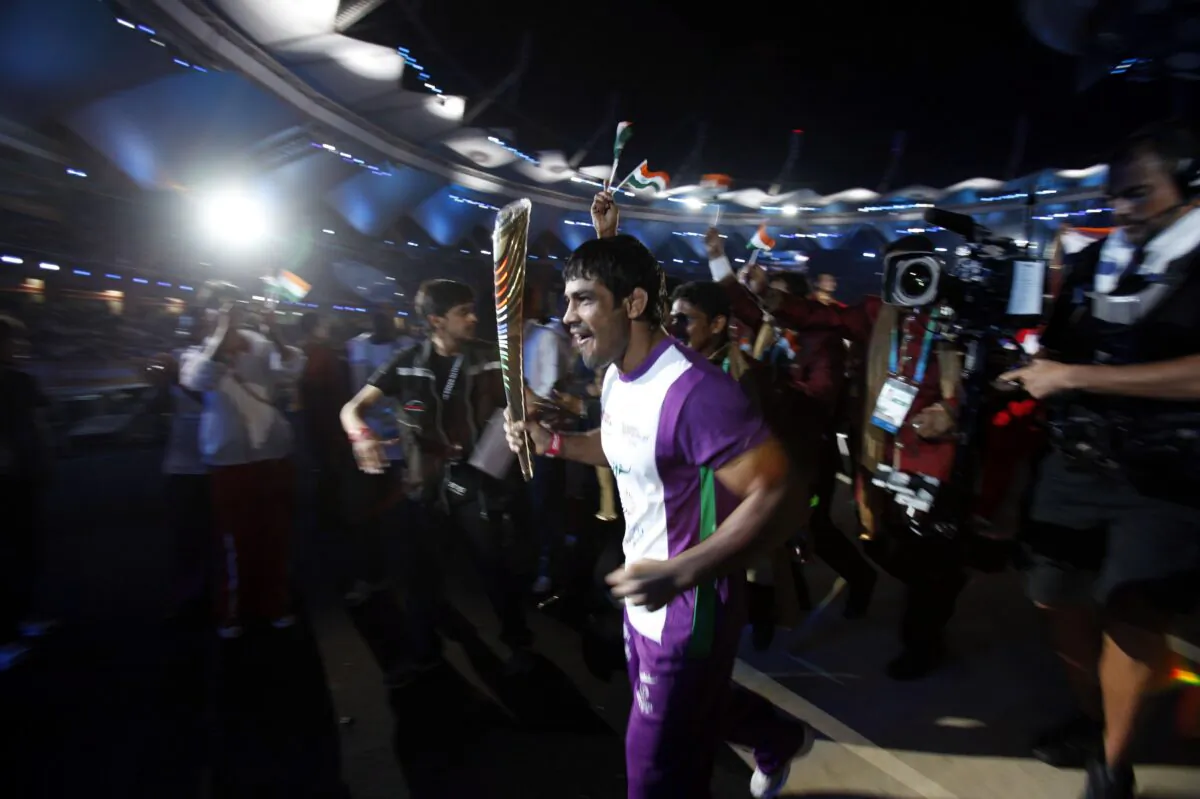 Indian wrestler Sushil Kumar runs as he holds the Queen's Baton during the opening ceremony for the Commonwealth Games at the Jawaharlal Nehru Stadium in New Delhi, on Oct. 3, 2010. (Adnan Abidi/Reuters)