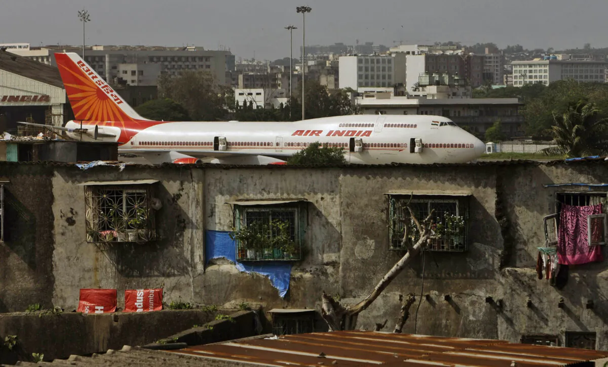 An Air India plane is seen in the background of slums adjoining the the international airport in Mumbai, India, on May 25, 2010. (Rajanish Kakade/AP Photo)
