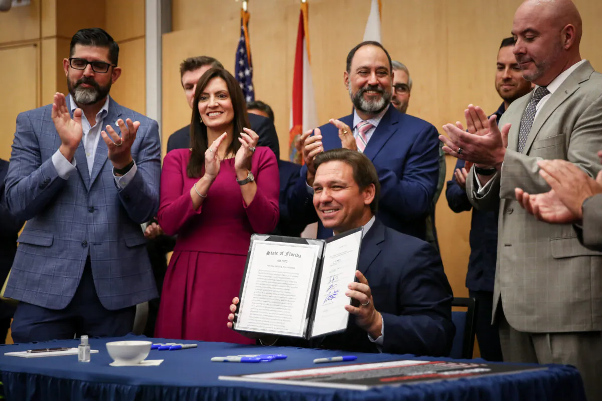 Florida Gov. Ron DeSantis signs into law Senate Bill 7072 at Florida International University in Miami on May 24, 2021. (Samira Bouaou/The Epoch Times)