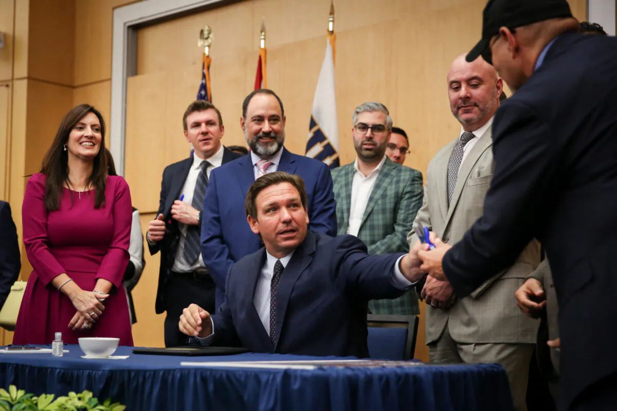 Florida Gov. Ron DeSantis signs into law Senate Bill 7072 at Florida International University in Miami on May 24, 2021. (Samira Bouaou/The Epoch Times)