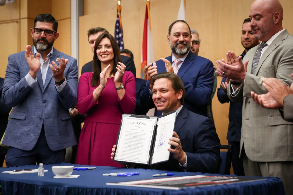 Florida Gov. Ron DeSantis signs into law Senate Bill 7072 at Florida International University in Miami on May 24, 2021. (Samira Bouaou/The Epoch Times)