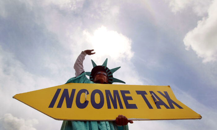 A man holding a sign advertising a tax preparation office in Miami, Fla., on April 14, 2010. (Joe Raedle/Getty Images)