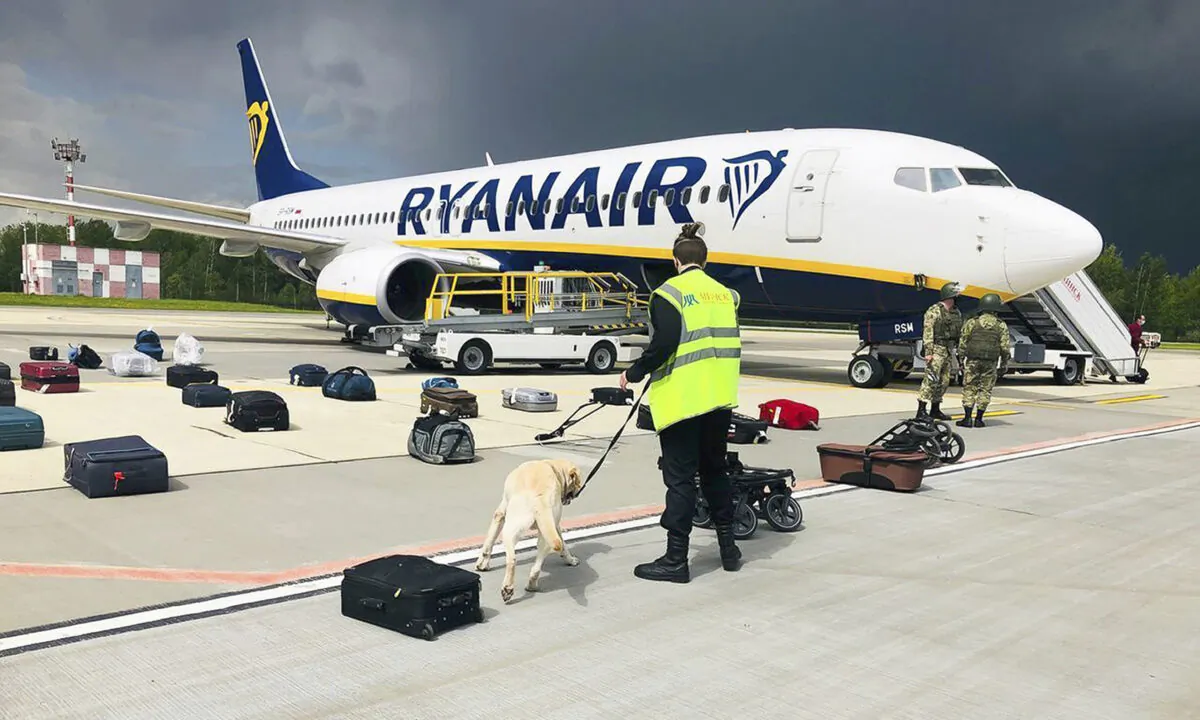 Security use a sniffer dog to check the luggage of passengers on the Ryanair plane with registration number SP-RSM, carrying opposition figure Raman Pratasevich which was traveling from Athens to Vilnius and was diverted to Minsk after a bomb threat, in Minsk International Airport in Belarus on May 23, 2021. (ONLINER.BY via AP)