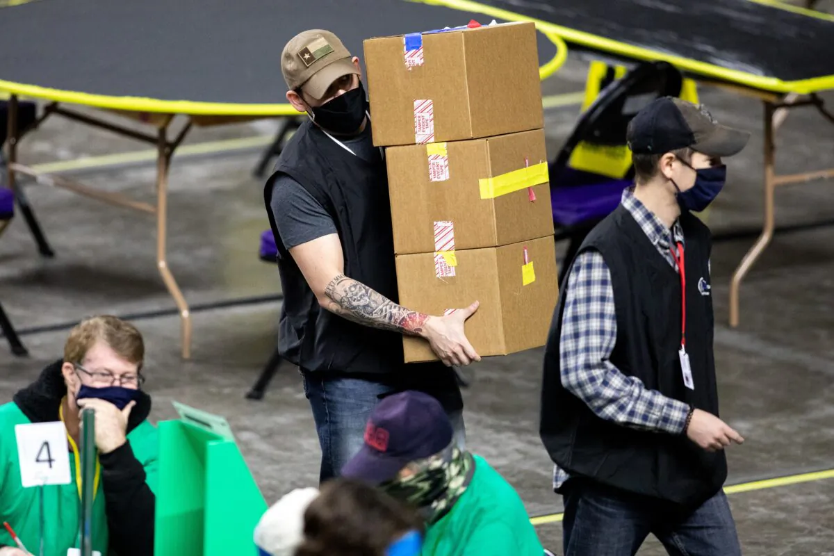 Contractors working for Cyber Ninjas, which was hired by the Arizona Senate, examine and recount ballots from the 2020 general election at Veterans Memorial Coliseum in Phoenix, Ariz., on May 1, 2021. (Courtney Pedroza/Getty Images)
