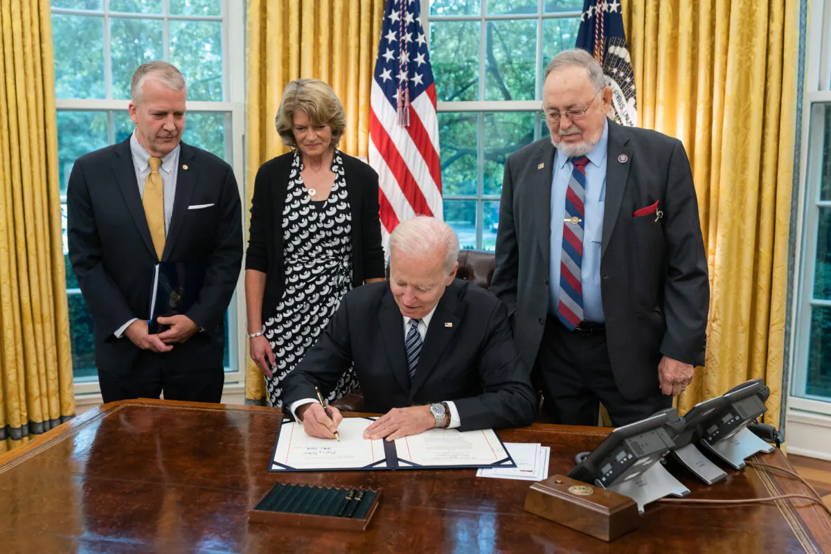 Sens. Dan Sullivan (R-Alaska) and Lisa Murkowski (R-Alaska), and Rep. Don Young (R-Alaska) look on as President Joe Biden signs the Alaska Tourism Restoration Act, in the Oval Office of the White House, in Washington, on May 24, 2021. (Official White House Photo by Adam Schultz)