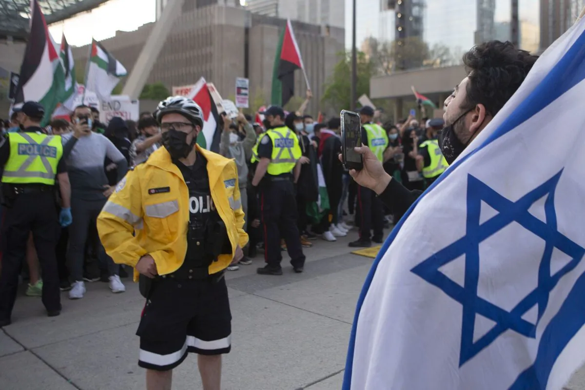 Police officers separate opposing Palestinian and Israeli supporters during a demonstration against the fighting in the Gaza Strip, in Toronto on May 15, 2021. (THE CANADIAN PRESS/Chris Young)