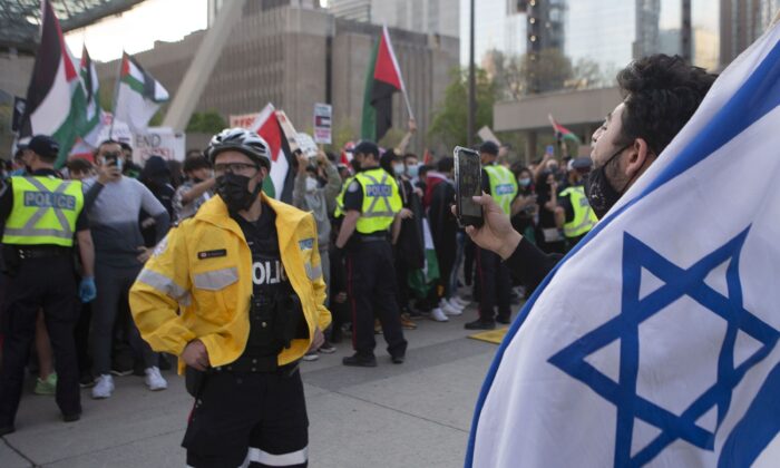 Police officers separate opposing Palestinian and Israeli supporters during a demonstration against the fighting in the Gaza Strip, in Toronto on May 15, 2021. (THE CANADIAN PRESS/Chris Young)