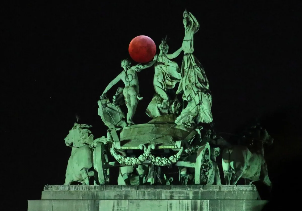 The moon is seen beside a quadriga on the top of the Cinquantenaire arch during a total lunar eclipse, known as the "Super Blood Wolf Moon," in Brussels on Jan. 21, 2019. (Yves Herman/Reuters)