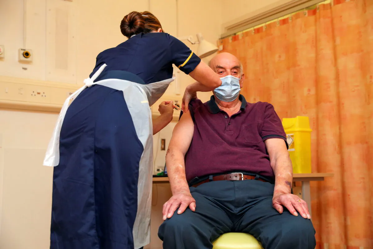 Brian Pinker, 82, receives the Oxford University/AstraZeneca CCP virus vaccine from nurse Sam Foster at the Churchill Hospital in Oxford, England, on Jan. 4, 2021. (Steve Parsons/Pool via Reuters)