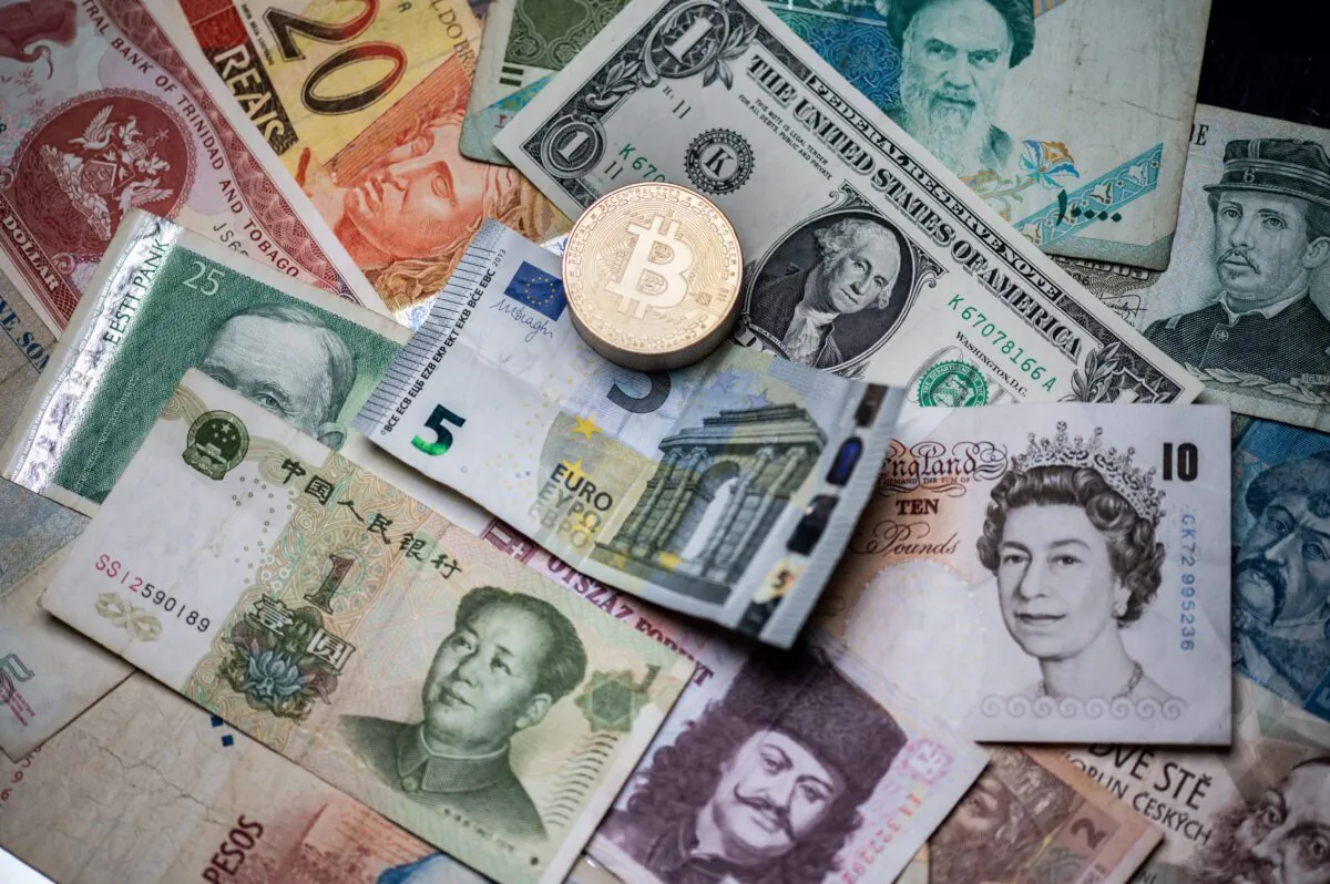 A physical imitation of the Bitcoin crypto currency displayed on foreign bank notes in Paris, France, on April 26, 2021. (Martin Bureau/AFP via Getty Images)