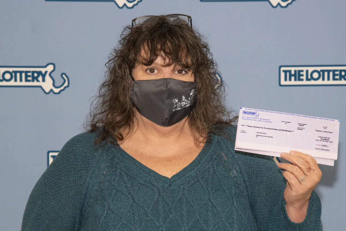 Lea Rose Fiega displays a winning lottery ticket at Lottery Commission headquarters in Boston, Mass., on March 30, 2021. (Massachusetts Lottery Commission Photo via AP)