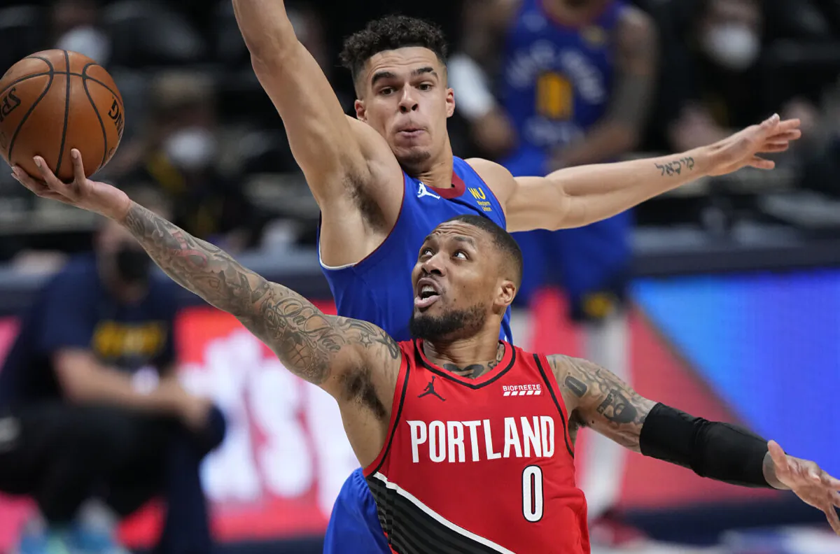 Portland Trail Blazers guard Damian Lillard (0) shoots next to Denver Nuggets forward Michael Porter Jr. (1) during the second half of Game 1 of a first-round NBA basketball playoff series in Denver, Colo., on May 22, 2021. (Jack Dempsey/AP Photo)