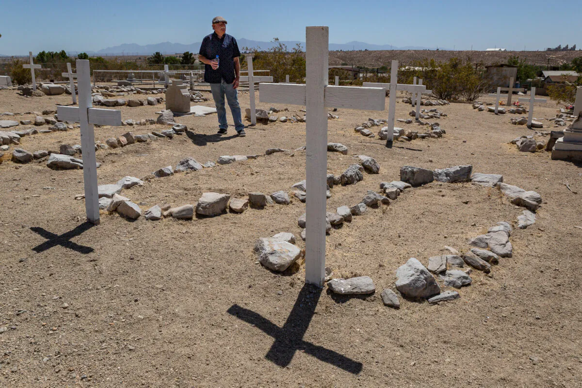 Honorary Mayor Joe Manners walks through the cemetery in Oro Grande, Calif., on May 18, 2021. (John Fredricks/The Epoch Times)