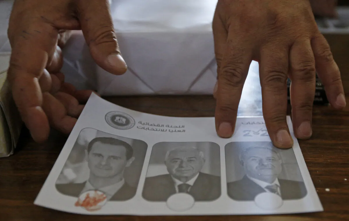 A Syrian votes for President Bashar al-Assad by marking the ballot with blood at a polling station in Damascus on May 26, 2021, as voting for Syria's presidential election started in government-held areas despite accusations it was neither "free nor fair". The controversial vote is the second election since the start of a decade-long civil war that has killed more than 388,000 people and displaced half the pre-war population. (LOUAI BESHARA/AFP via Getty Images)