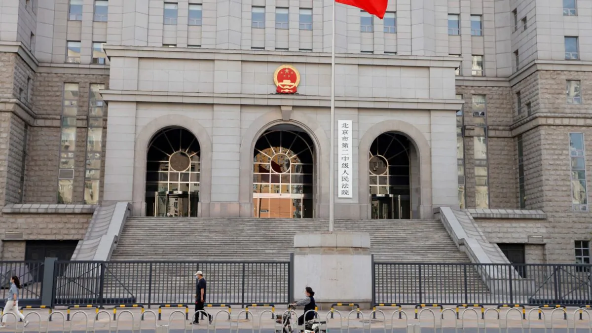People walk past one of the entrances of Beijing No. 2 Intermediate People's Court where Australian writer Yang Hengjun is expected to face trial on espionage charges, in Beijing, China, on May 27, 2021. (Carlos Garcia Rawlins/Reuters, File Photo)