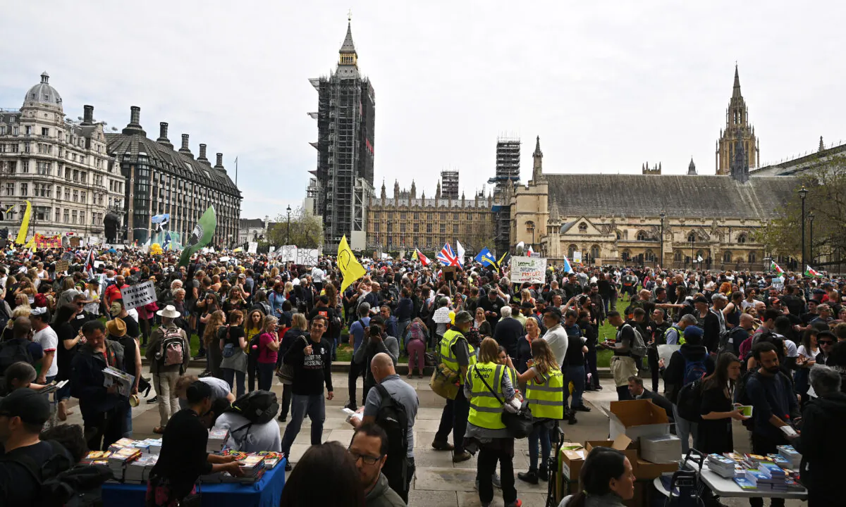 Demonstrators hold placards as they gather for a 'Unite For Freedom' rally against CCP virus restrictions and vaccine passports, in Parliament Square, central London on May 29, 2021. (Ben Stansall/AFP via Getty Images)