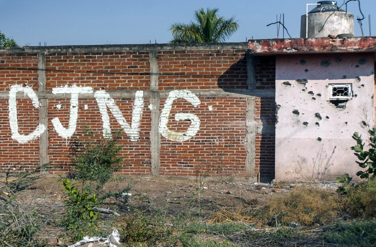View of a bullet-riddled wall bearing the initials of the criminal group Cártel de Jalisco Nueva Generación at the entrance of the community of Aguililla, Mexico, on April 23, 2021. (Enrique Castro/AFP via Getty Images)
