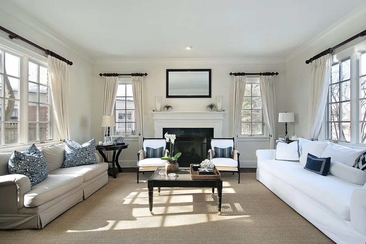 A living room that incorporates classical principles of design. The use of horizontal lines is emphasized by the crown molding and curtain rods, while the vertical lines are emphasized with the curtains. The sofas and chairs visually draw your eyes to the room’s overall horizontal lines, which are reinforced with the window lines, fireplace, and coffee table. (Lmphot/Dreamstime.com)