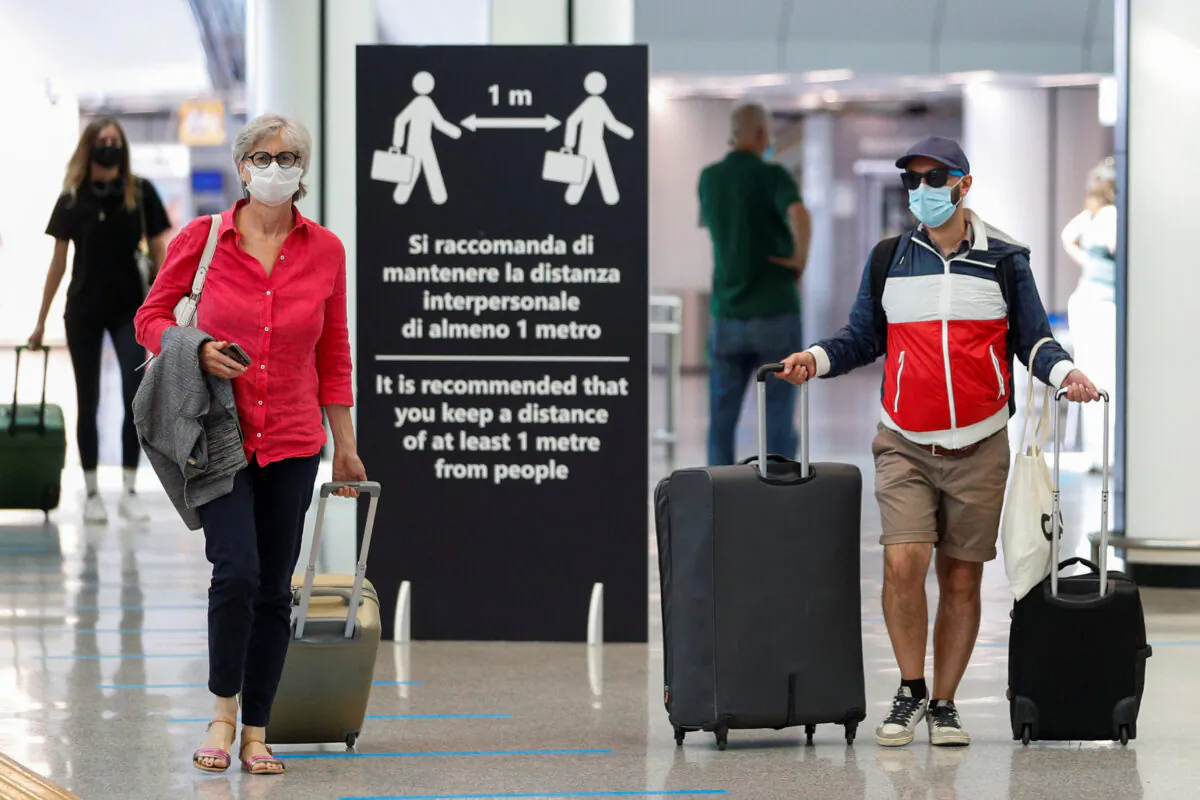 Passengers wearing protective masks walk at Fiumicino Airport, in Rome, Italy, on June 30, 2020. (Guglielmo Mangiapane/Reuters)