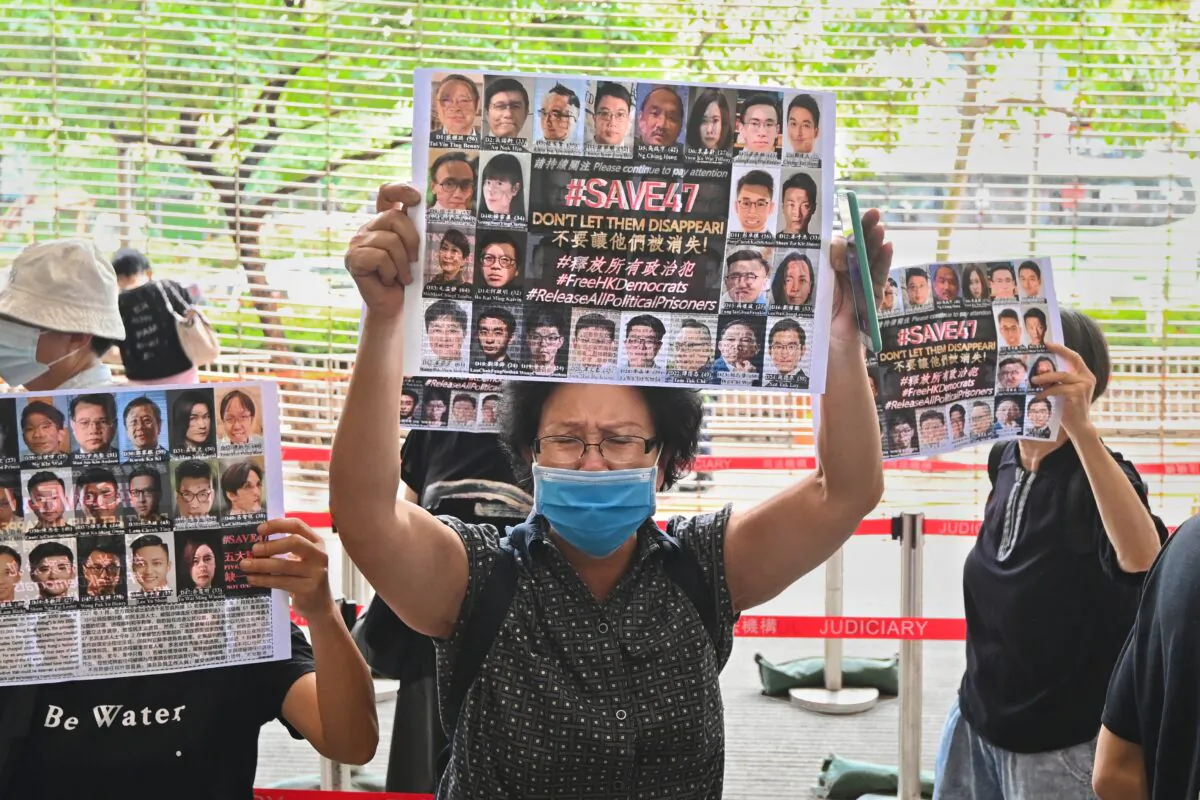 A woman holds up a paper with the words #Save47 outside of the West Kowloon court building in Hong Kong on May 31, 2021. (Sung Pi-lung/The Epoch Times)