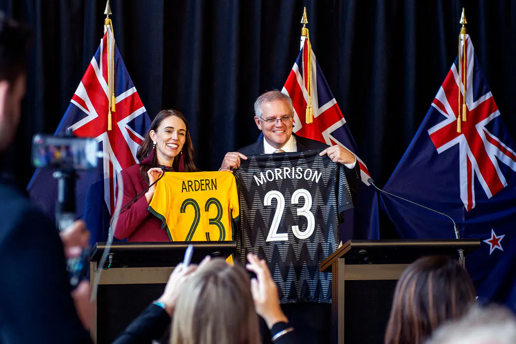 New Zealand Prime Minister Jacinda Ardern and Australian Prime Minister Scott Morrison swap football jersey's during a dual prime ministers press conference in Queenstown, New Zealand on May 31, 2021 (Joe Allison/Getty Images)